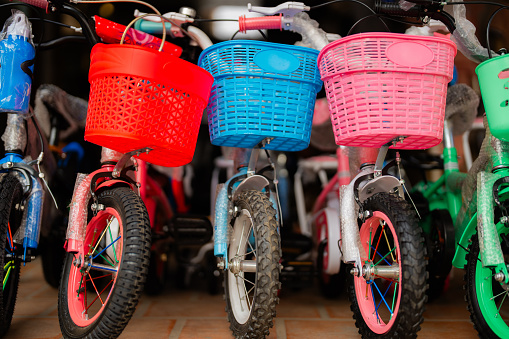 colourful bicycles with baskets standing in the row