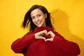 Photo of young women in winter wear standing on yellow background stock photo