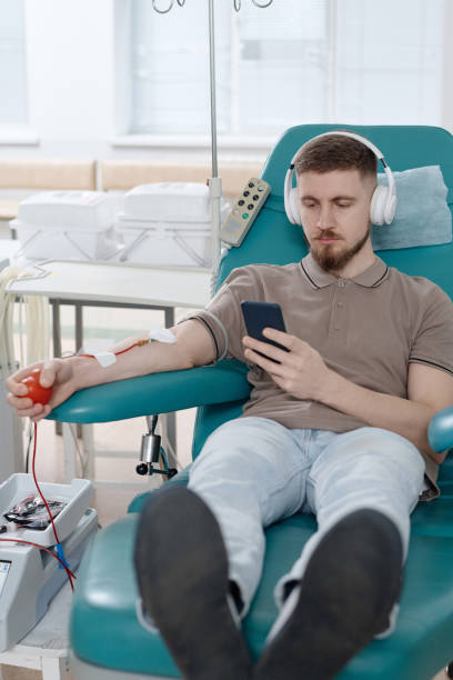 jovem branco participando de transfusão de sangue em centro médico - pumping blood audio - fotografias e filmes do acervo