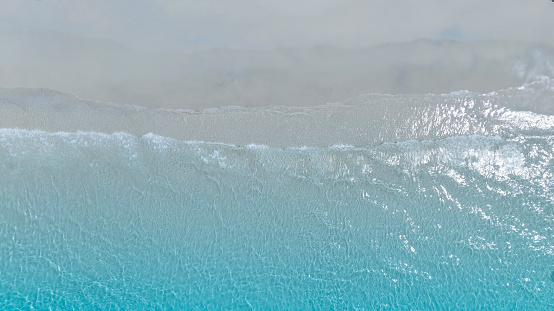 The soft wave water of the sea on the sandy beach background