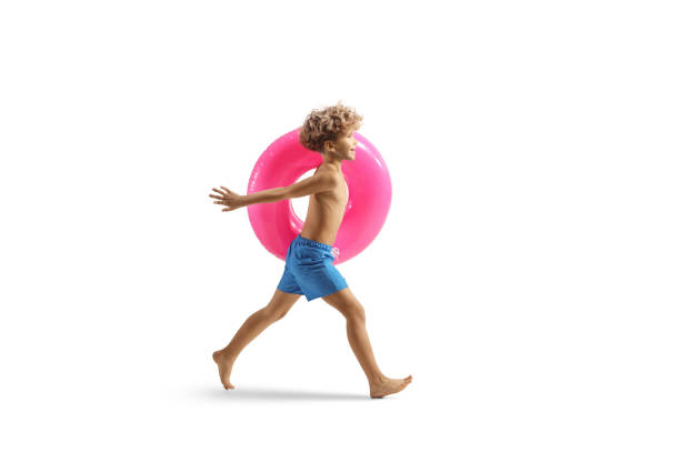 Boy running with a pink rubber swimming ring isolated on white background