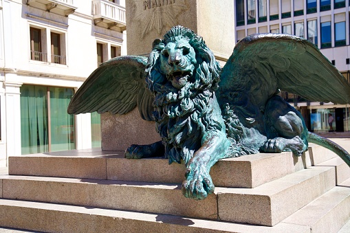 Bronze sculpture of lying lion with wings at town square of City of Venice on a sunny summer day. Photo taken August the 7th, 2023, Venice, Italy.