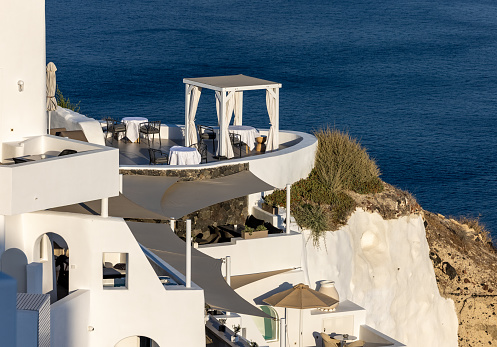 Oia, Santorini, Greece - June 28, 2021: Whitewashed houses with terraces and pools and a beautiful view in Oia on Santorini island, Greece