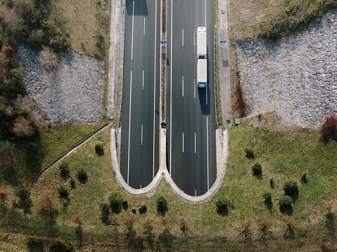 Aerial view of a highway with tunnel entrances and a truck