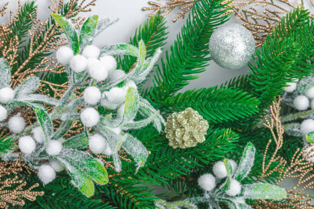 istock Traditional New Year composition. Festive decor, snowy Christmas tree branches, balls, flowers 1972232642