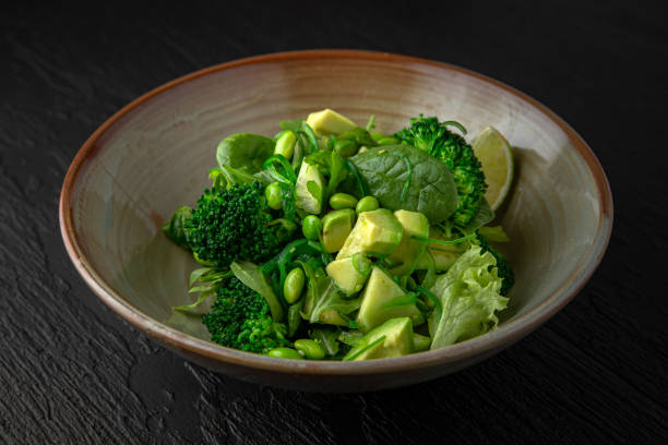 istock Green Salad from avocado, beans, broccoli in a ceramic plate on a dark textured background. Restaurant menu 1972245298