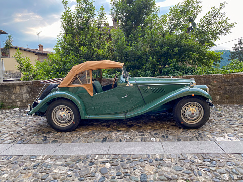 Castell'Arquato, Italy - June 25 2023 vintage old MC TC Midget parked on a pebble street in a medieval village on the hills of Emilia Romagna Italy