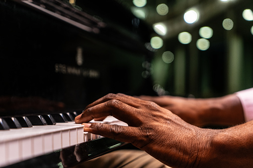 Close-up of a man's hand playing piano