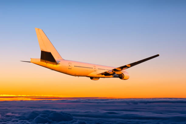 istock White wide body passenger jetliner fly in the sunset sky 1972294959