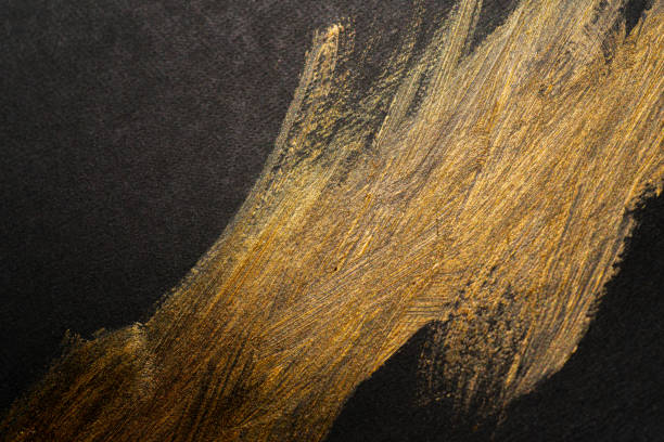istock golden paint on black background 1972299243