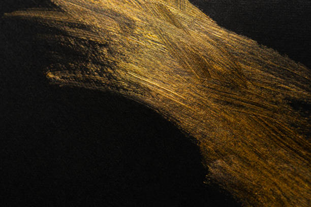 istock golden paint on black background 1972299775