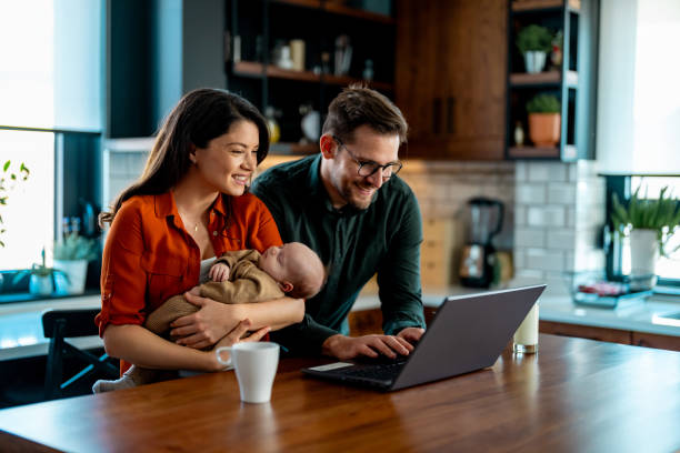 Couple going over home finances with a newborn Couple going over home finances with a newborn starting a family stock pictures, royalty-free photos & images