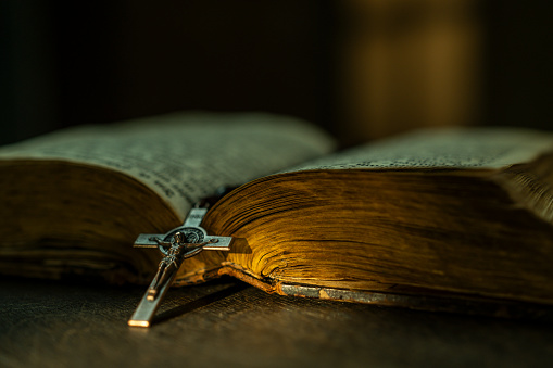 Open Holy Bible and crucifix on wooden background