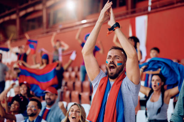 istock Excited sports fan cheering form stadium stands. 1972316982