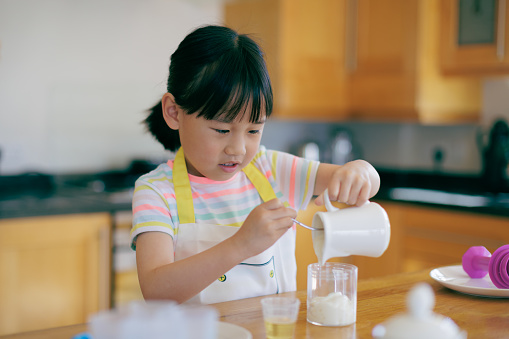 medium shot young  girl was preparing food at home kitchen