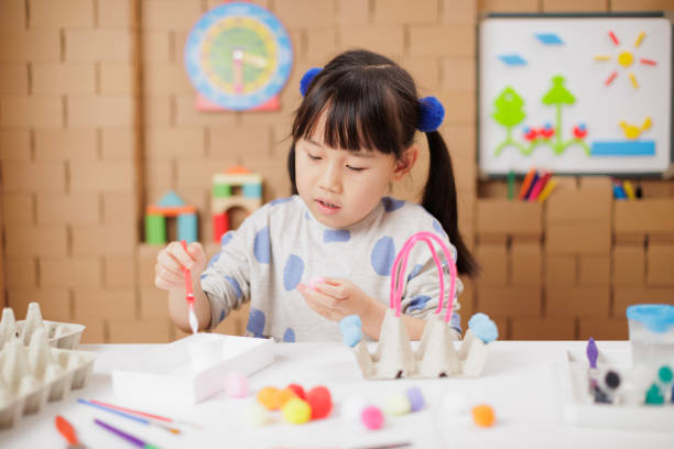 medium shot of young girl making craft at home