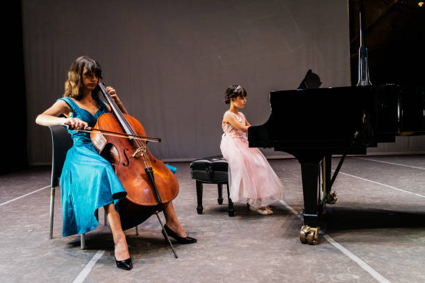 istock Sisters playing piano and cello at stage theater 1972322400