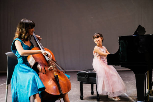 istock Sisters playing piano and cello at stage theater 1972322929