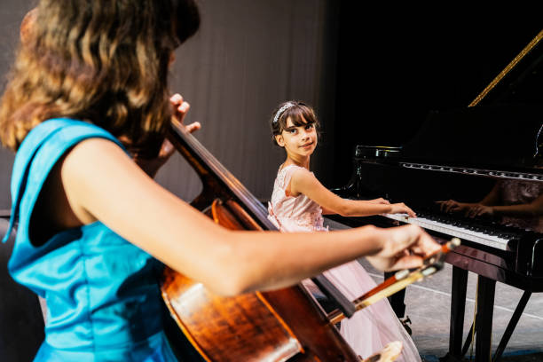 istock Sisters playing piano and cello at stage theater 1972322931