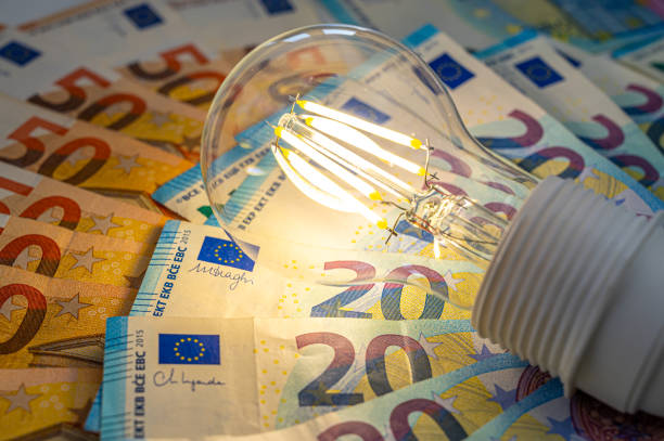 istock Light bulb on, on top of banknotes. 1972324643