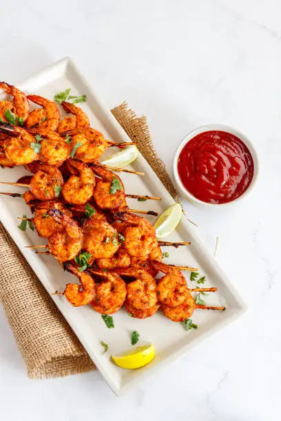 Roasted Shrimp on Skewers in a Tray with Sauce Top Down Vertical Photo