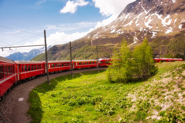 istock Red train moving in beautiful mountain landscape in Switzerland 1972352975