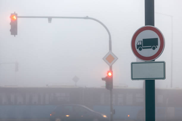 Traffic signs and road in smog, selective focus