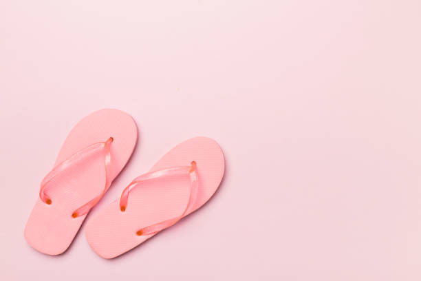 Bright flip flops on color background, top view