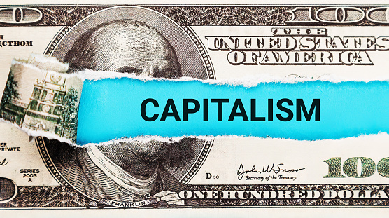 Capitalism. The word Capitalism in the background of the US dollar. Capitalism and Free Market Economy Concept. Wealth Creation, Competition, and Economic Growth Symbol.