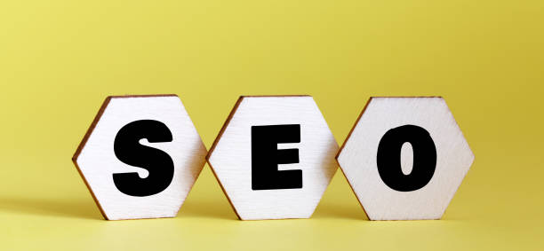 istock SEO word on small wooden blocks and yellow background. 1972383674