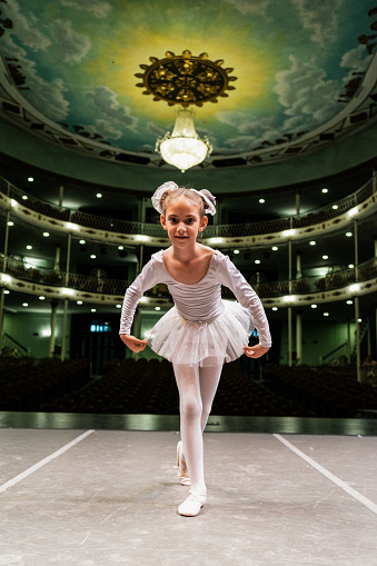 Portrait of a child ballerina rehearsing at stage theater