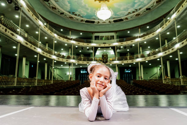 ritratto di una ballerina bambina sdraiata sul teatro del palcoscenico - performer theatrical performance stage china foto e immagini stock