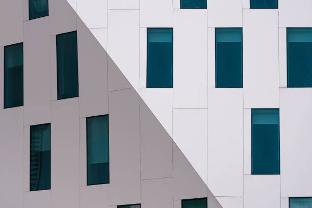 Many blue glass windows on geometric white building in modern style
