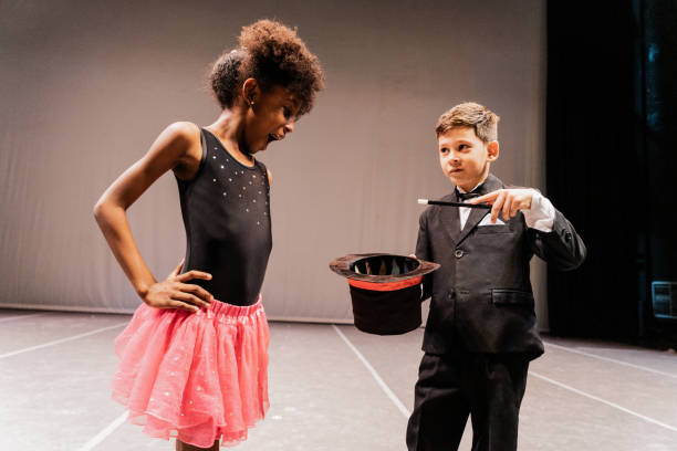 istock Child magician boy doing magics with the assistant on performance at stage theater 1972387161