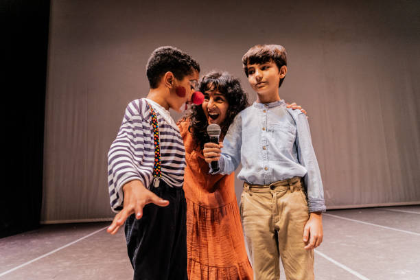 istock Child clown boy making jokes during presentation on stage theater 1972389105