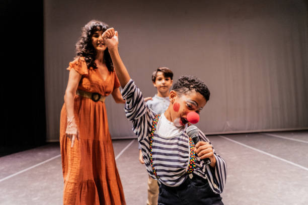 istock Child clown boy singing on the stage theater 1972389111
