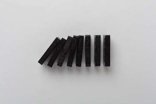 Black domino tiles on color background, top view