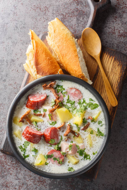 la zalewajka est une soupe polonaise traditionnelle à base de soupe de blé entier, de saucisses fumées, de bacon fumé aromatique et de légumes-racines en gros plan sur l’assiette. vue de dessus verticale - horseradish homemade eating food and drink photos et images de collection