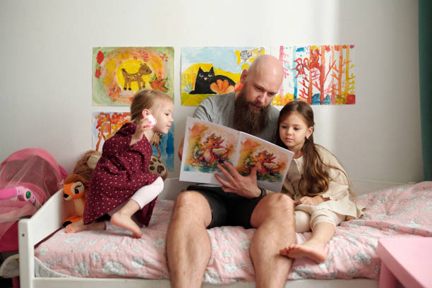 istock Bald man showing pictures in book 1972409957
