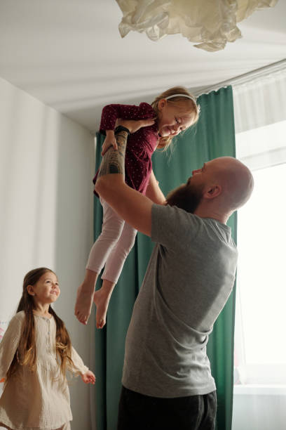 istock Happy man having fun with his daughters 1972409965