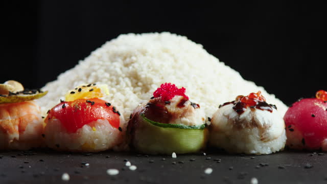 Close-up of rice and sushi on a dark background. Asian Chinese Thai Japanese Indian Traditional Food. Making sushi and rolls.