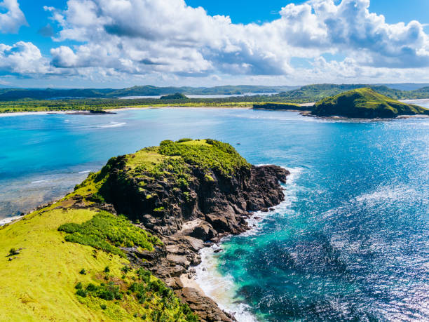 istock Coastal Landscape: Vibrant Green Hillside, Clear Blue Waters, Sandy Shoreline Under a Bright Sky with Fluffy Clouds, Lombok island. 1972442062