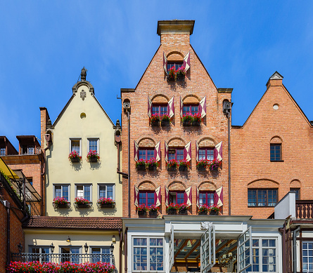 Facades of old medieval colorful houses in Gdansk. A walk through the city on a sunny summer day