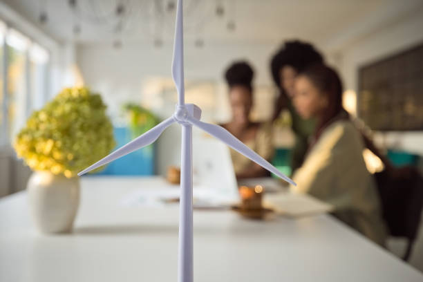 istock Wind turbine models against colleagues discussing in office 1972443149