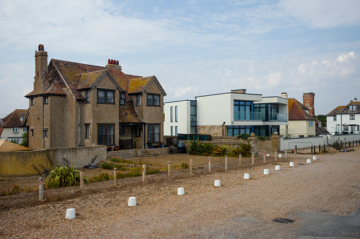 An old Gothic style house and a new Modernist style house sit side by side in Littlestone-on-Sea, Kent.