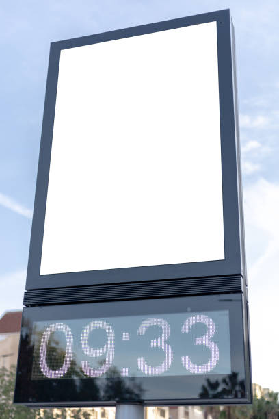 Urban digital clock post with a blank advertising panel against a cityscape, ideal for promotions. Vertical billboard mockup, empty display. Copy space for text, picture.