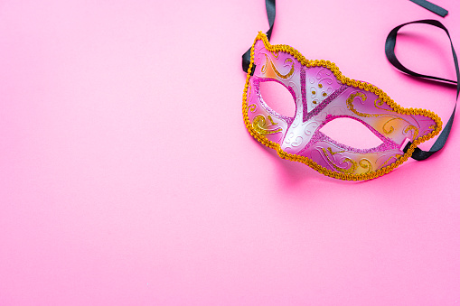 Pink mardi gras mask on pink background. High resolution 42Mp studio digital capture taken with Sony A7rII and Sony FE 90mm f2.8 macro G OSS lens