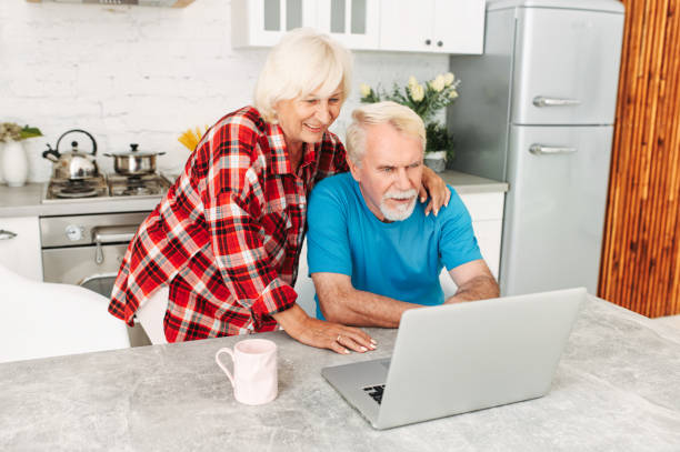 istock Senior couple with laptop at home 1972492112
