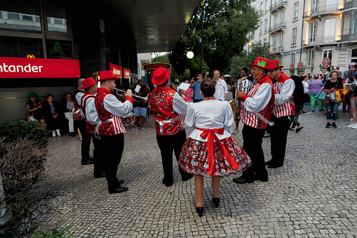 Lisbon, Portugal - June 12, 2022: Band musicians dressed in traditional folklore costumes rehearse before parading in Lisbon downtown, during this city celebrations of the Popular Saints.