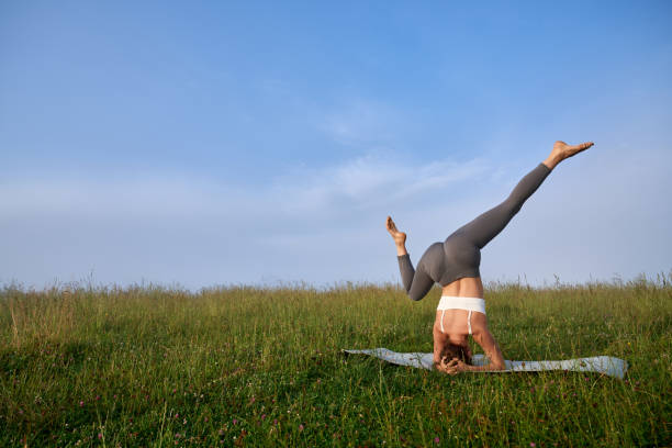 istock Strong woman practicing headstand position on nature 1972503305